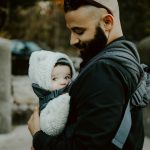 man carrying baby