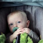 baby on gray stroller
